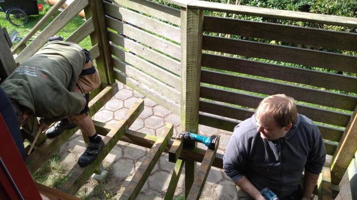 Isac og Sune lægger nye brædder til trappeopgangen